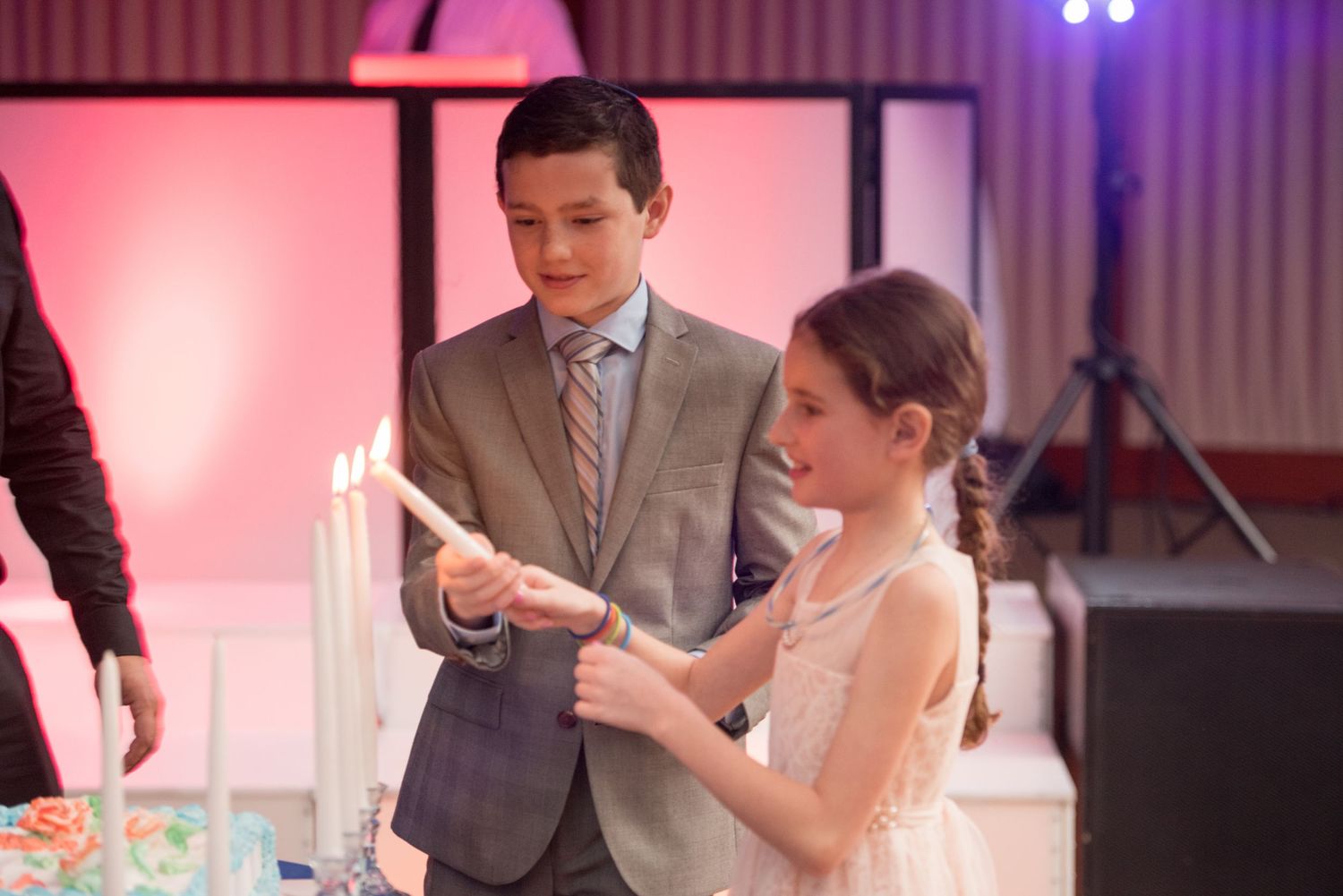 Couples dancing together at an evening celebration with pink and blue ambient lighting.