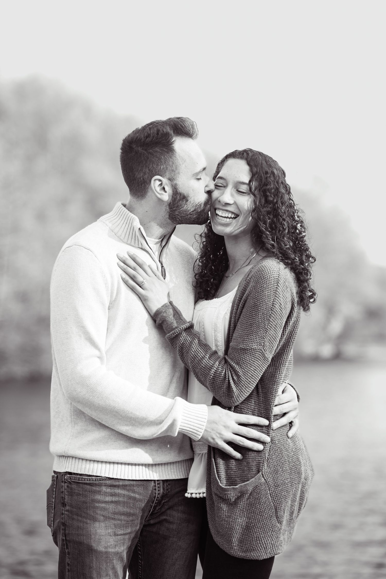 A romantic black and white photo series showing a couple embracing and laughing together outdoors.