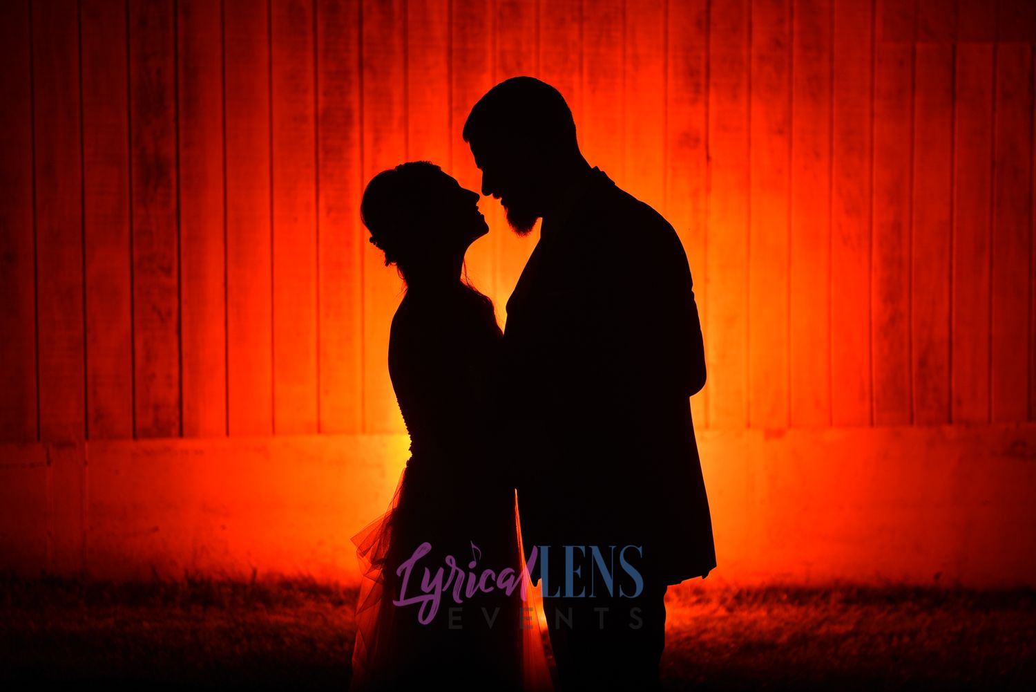 Silhouettes of a couple against a dramatic red-lit background creating a romantic atmosphere.