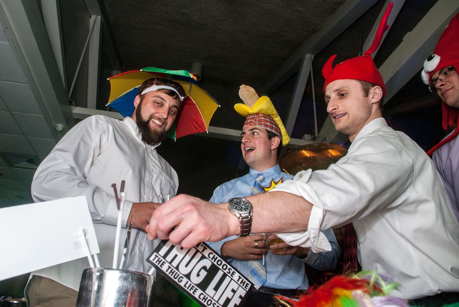 Party guests in white attire celebrating with colorful props and decorations.