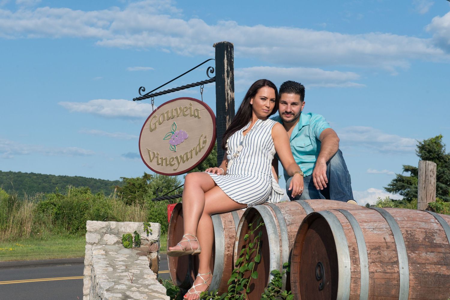 Romantic moments shared at a winery with wooden barrels and stone walls.