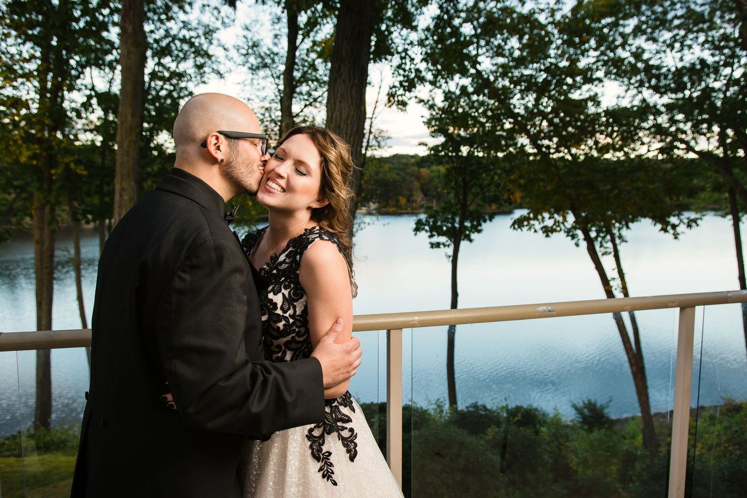 Lakeside wedding portraits with trees and water creating a serene natural backdrop.