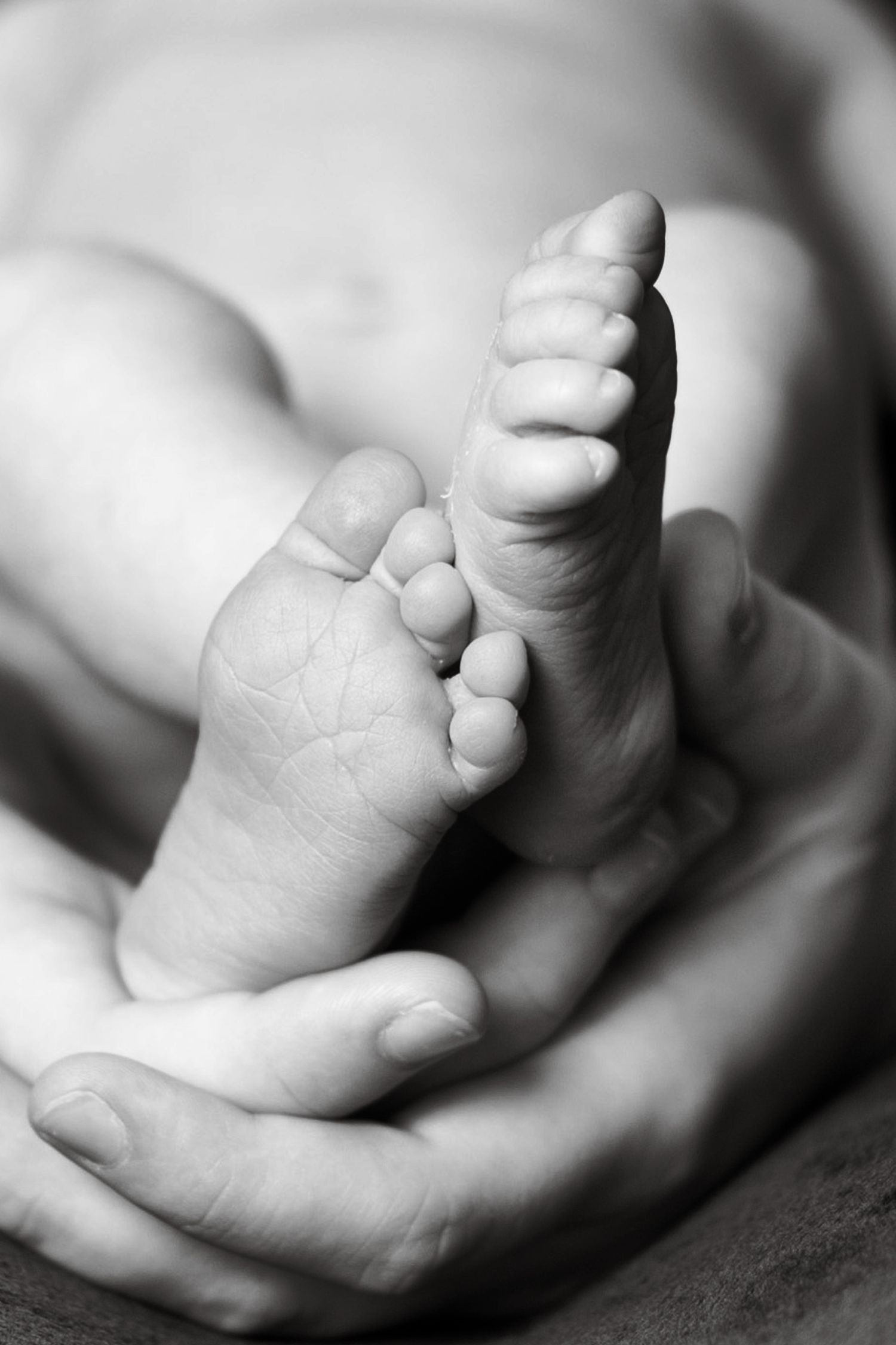 Close-up series of tiny baby feet in black and white.