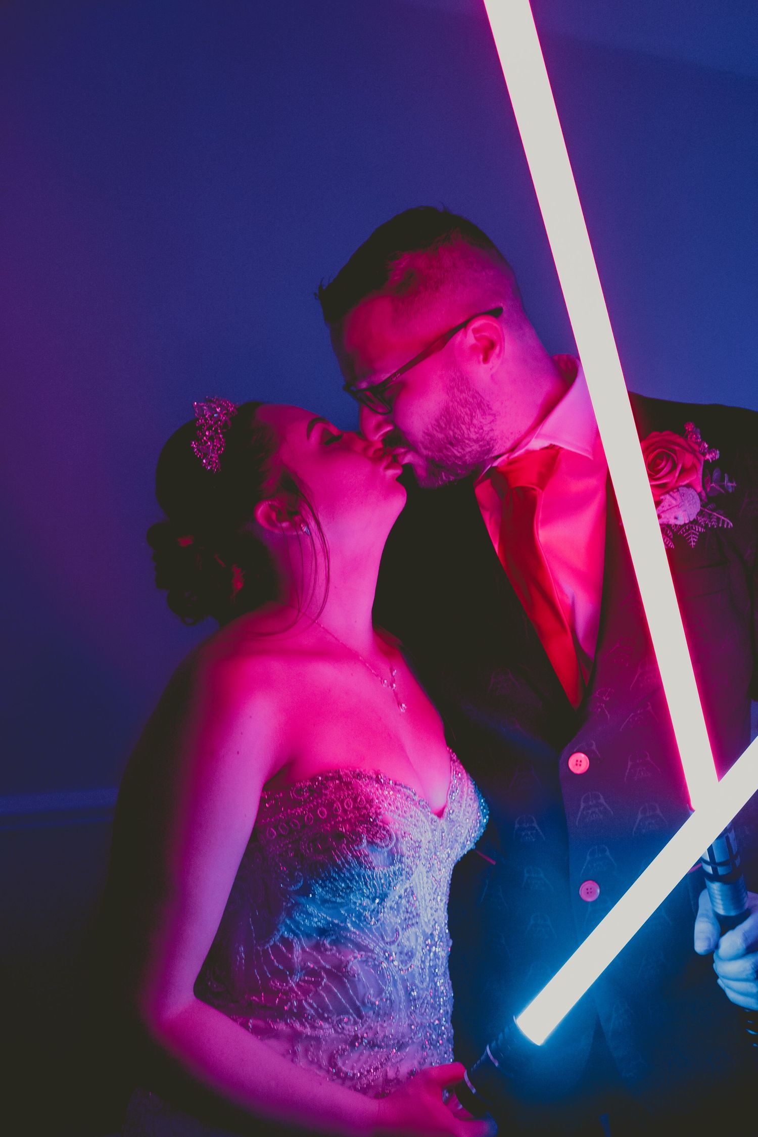 Dramatic wedding portraits with neon pink and blue lighting effects.