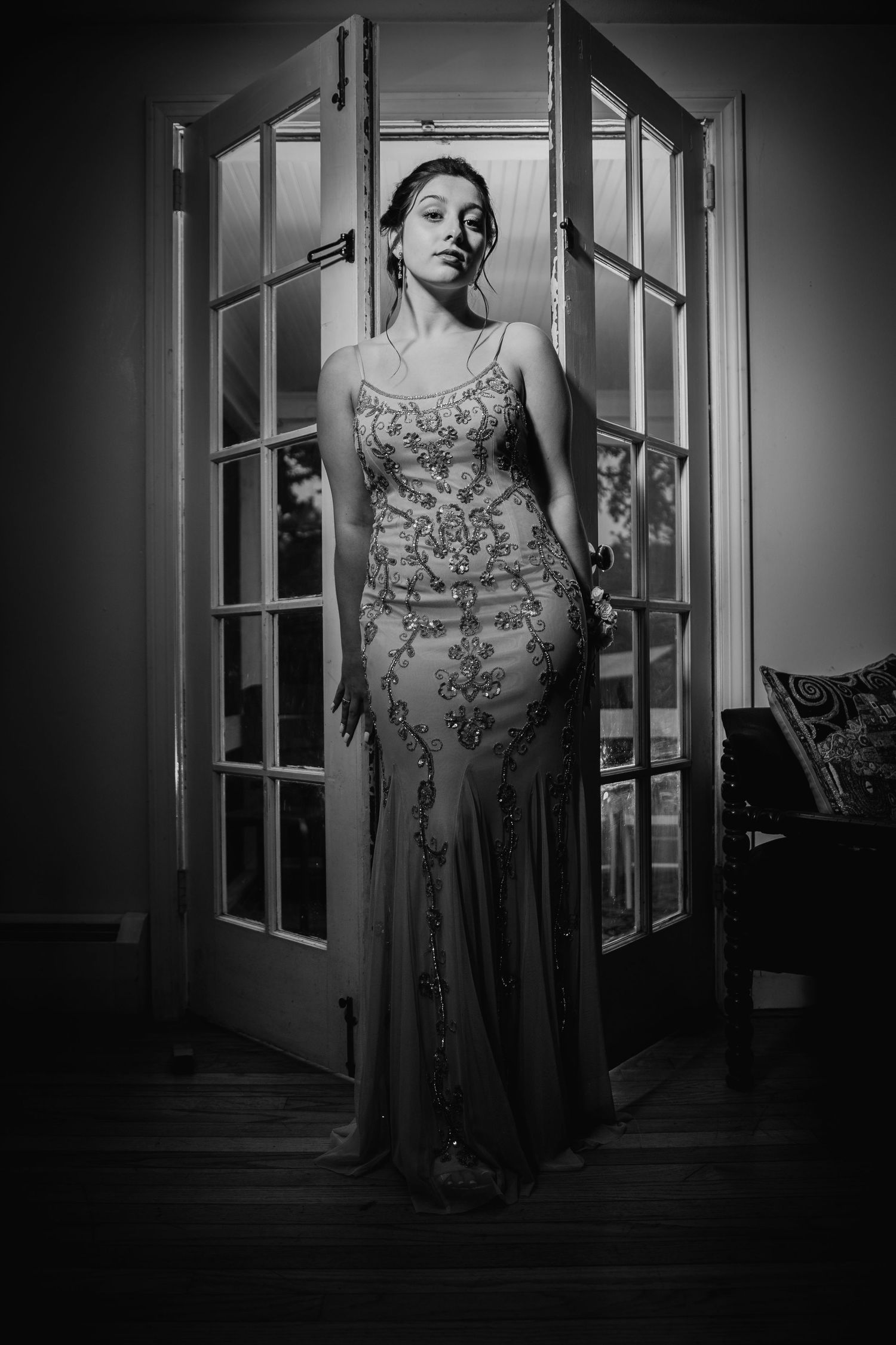Dramatic black and white portrait through French doors in evening wear.