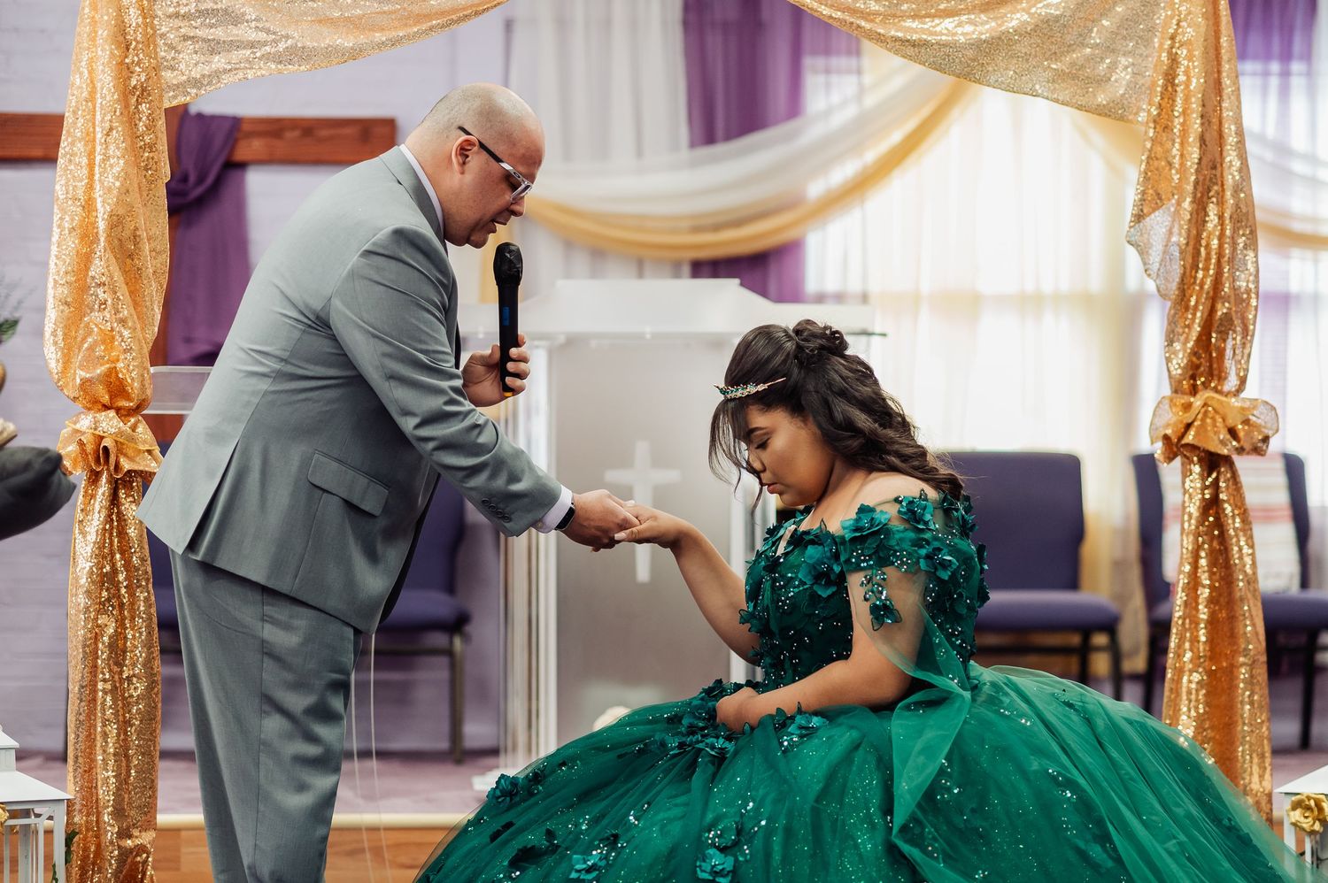Elegant wedding scene with gold and purple drapery decorating the venue.