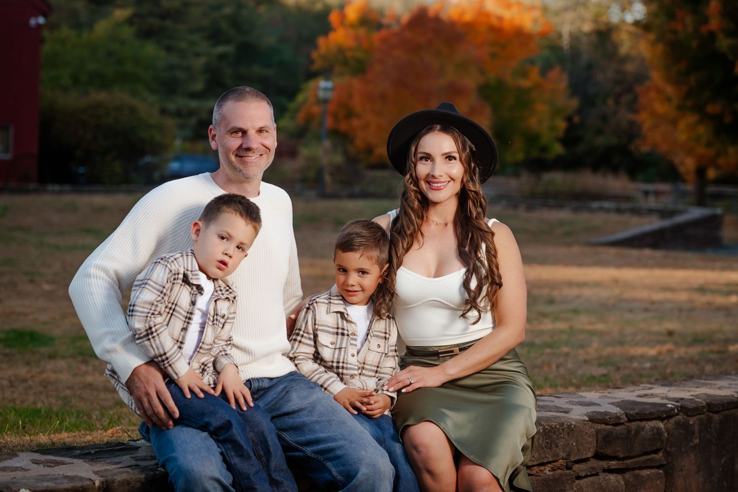 Family relaxing together on stone steps during an autumn outdoor photo session.