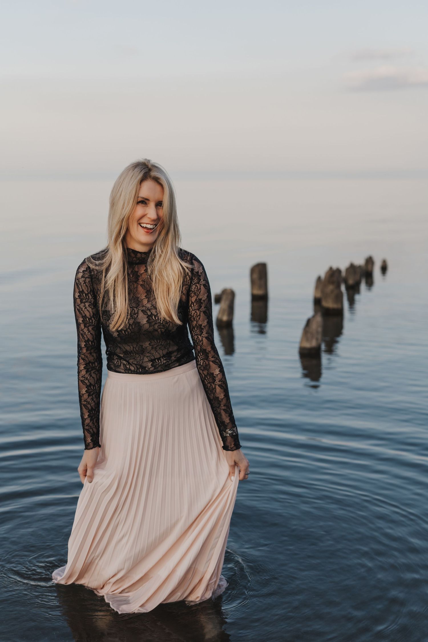 Michelle Hugill standing in calm lake water, holding her skirt.