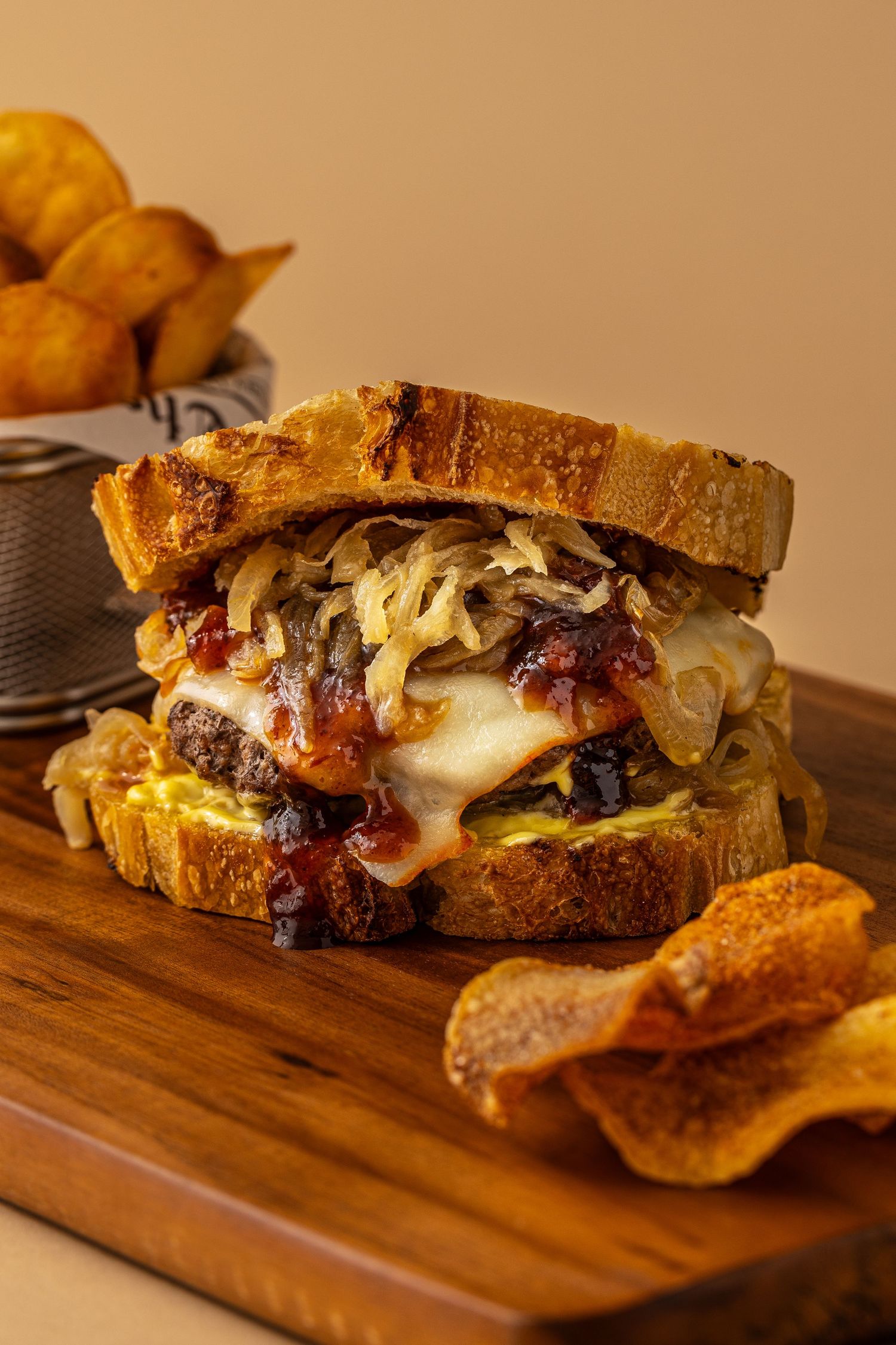 Hero shot of a scratch made cheeseburger on homemade sourdough bread with a side of chips made by Heartbakn in New Braunfels Texas