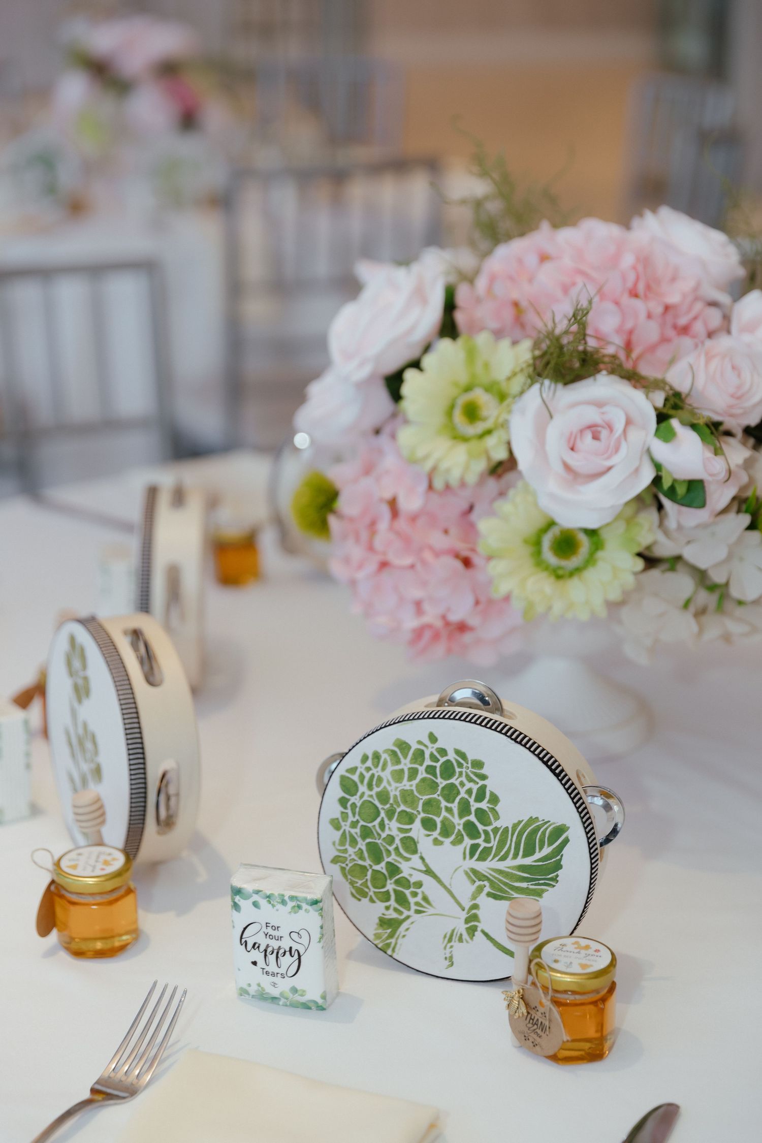 Wedding table decor with floral tambourines, honey jar favors, pink peonies, and roses centerpiece.