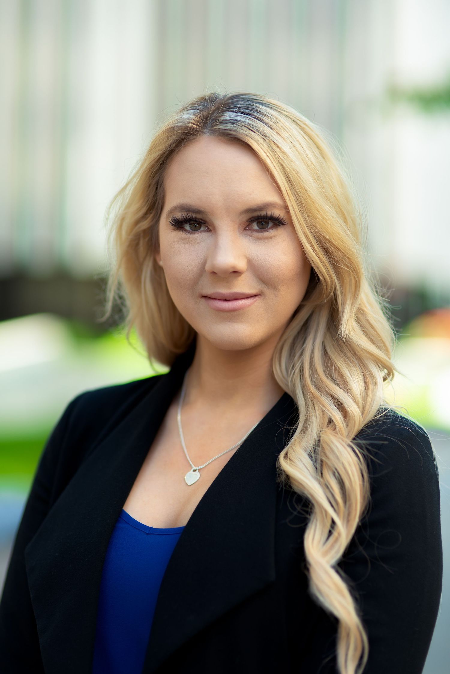 Corporate headshot series showing professional woman in black blazer and blue top.