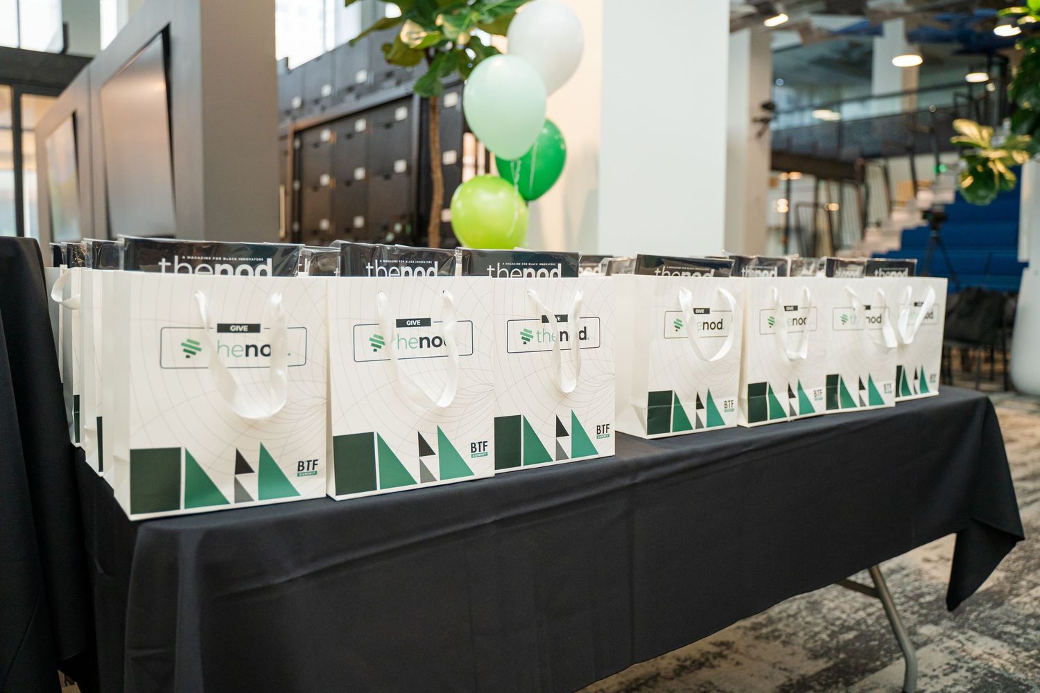 Row of promotional displays with green and white signage at an event.