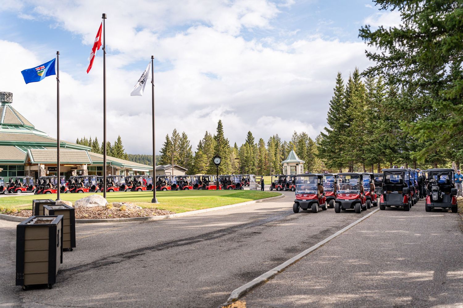 Panoramic view of a parking area with flags and golf carts against a cloudy sky.