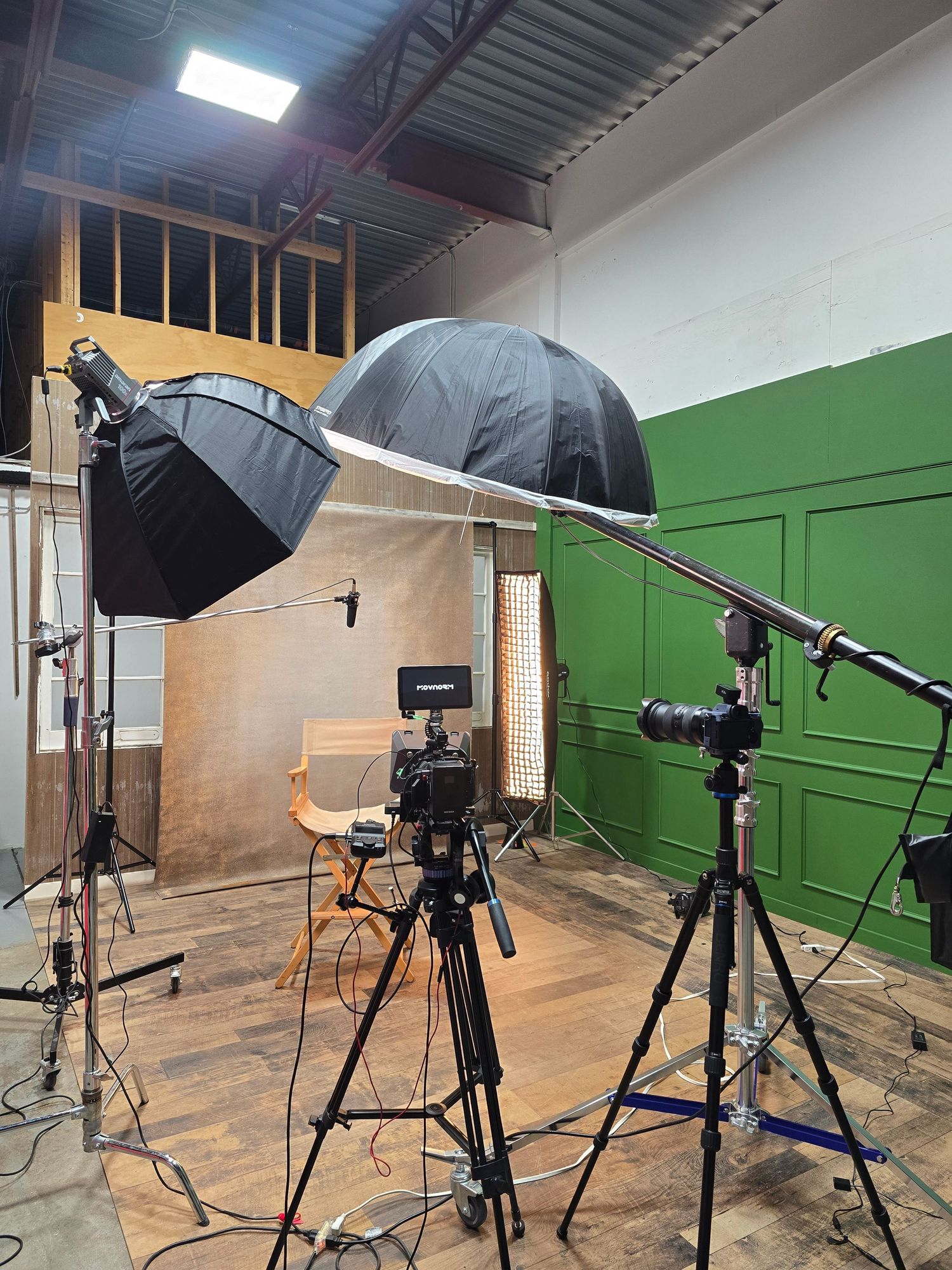 Photography studio setup with lighting equipment and green screen backdrop.