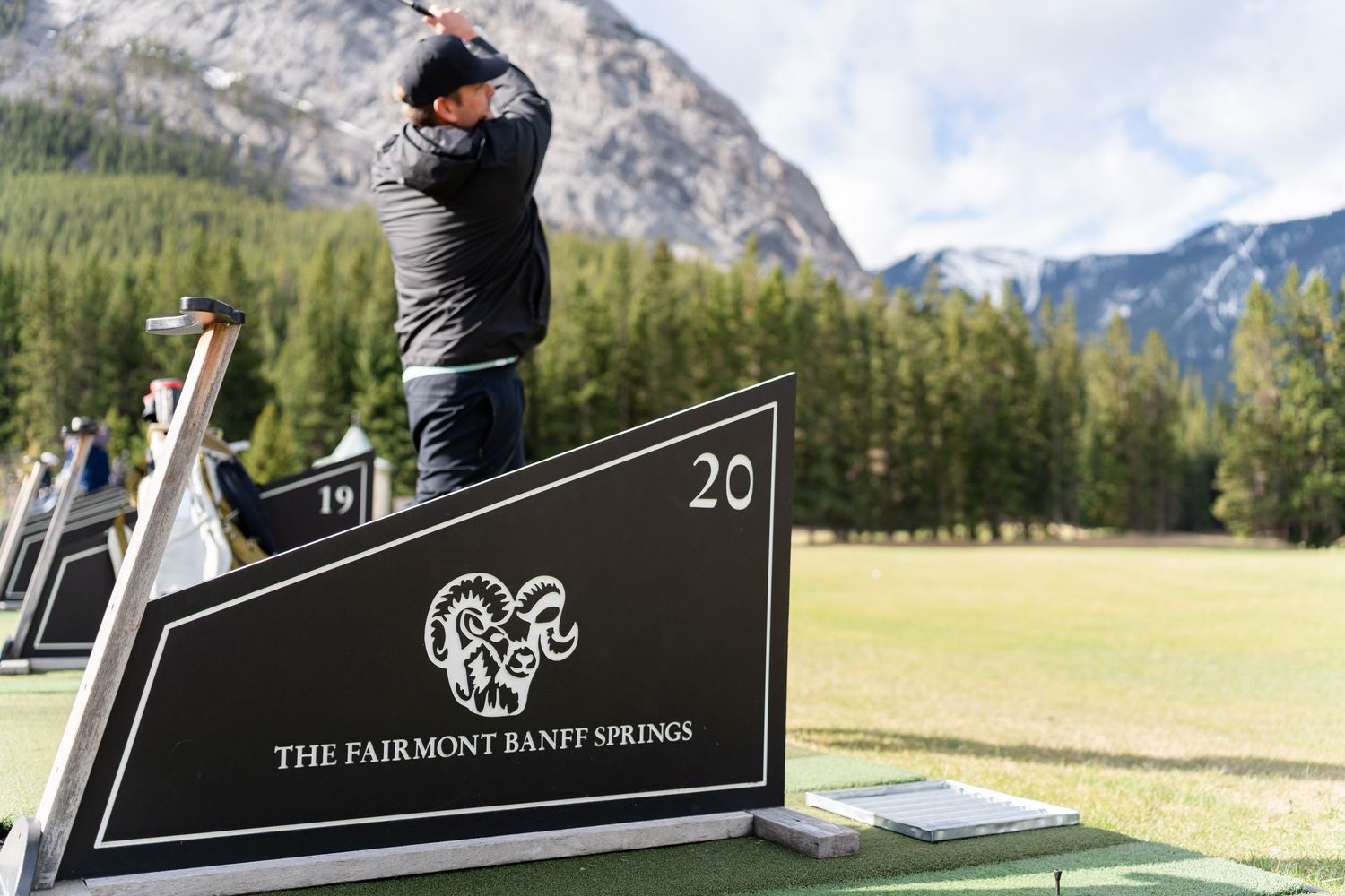 Golf course landscape with mountain views and signage in natural outdoor setting.