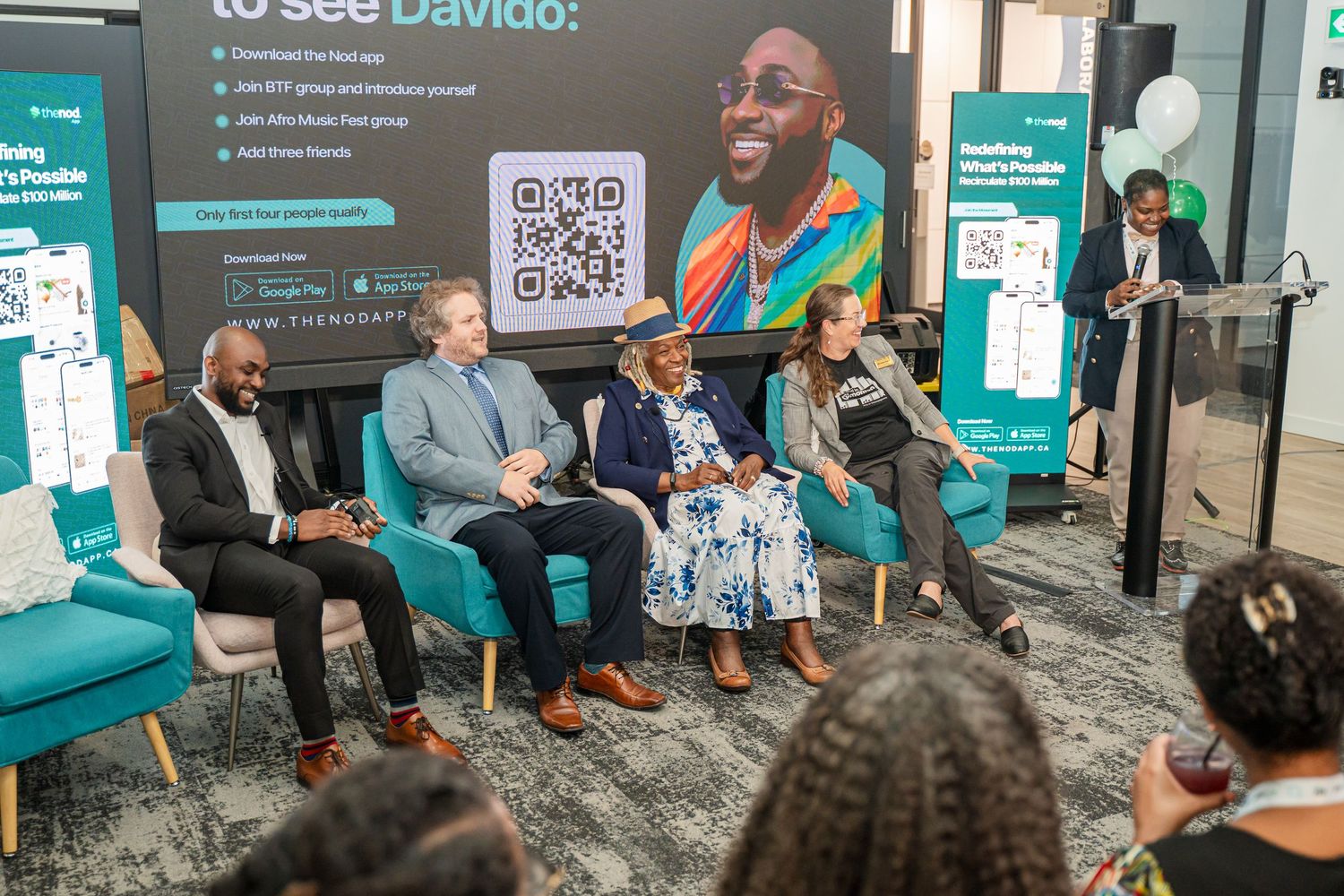 Panel discussion setup with speakers seated in modern office environment.
