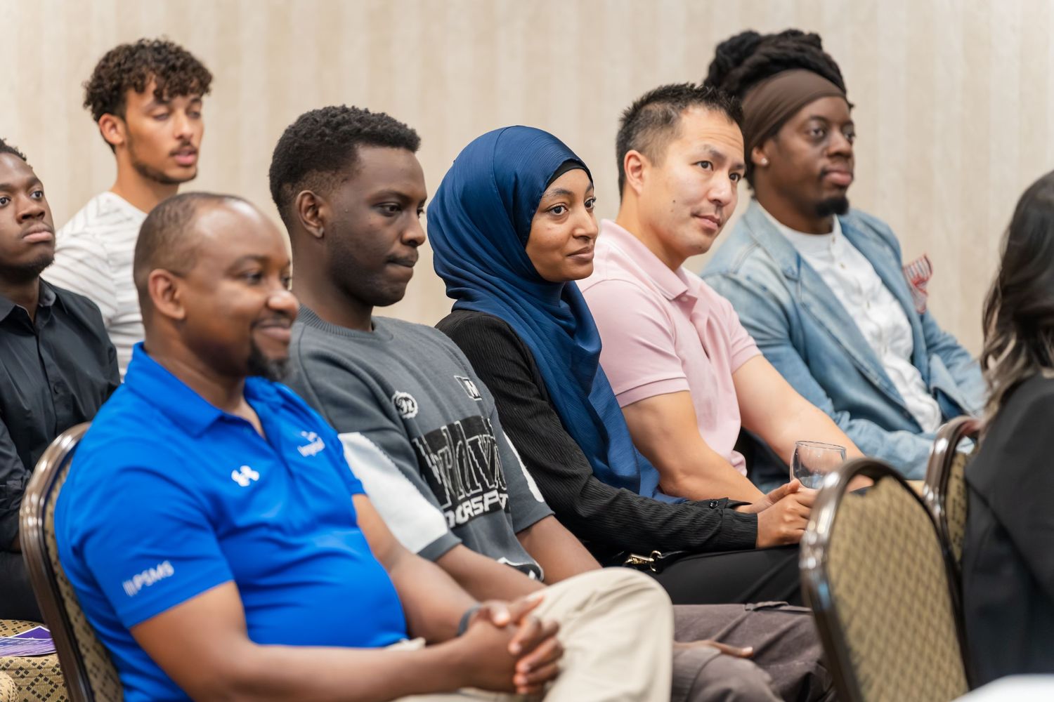 Diverse audience members seated and engaged during a presentation.