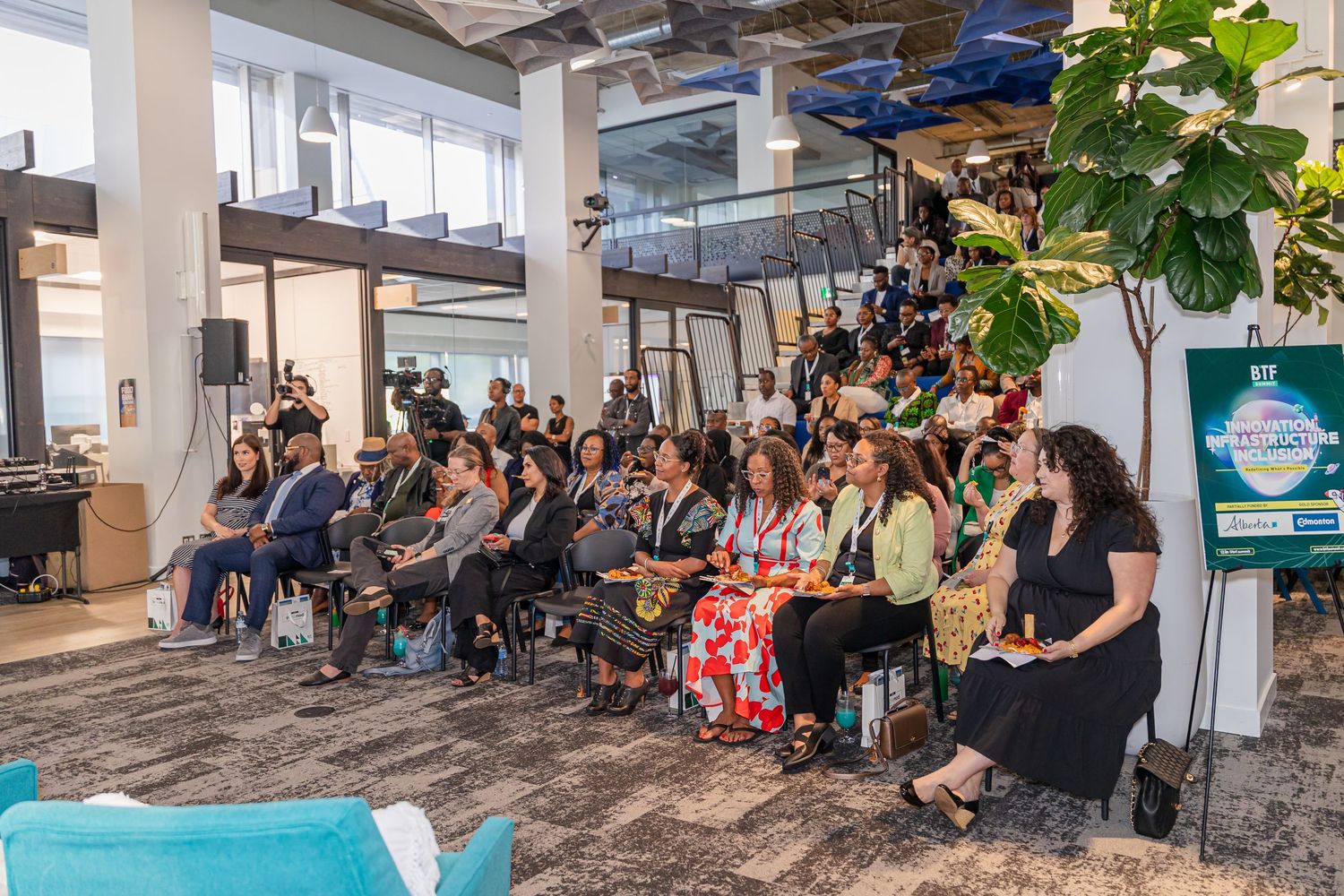 Large group of attendees seated in rows at a professional business event.