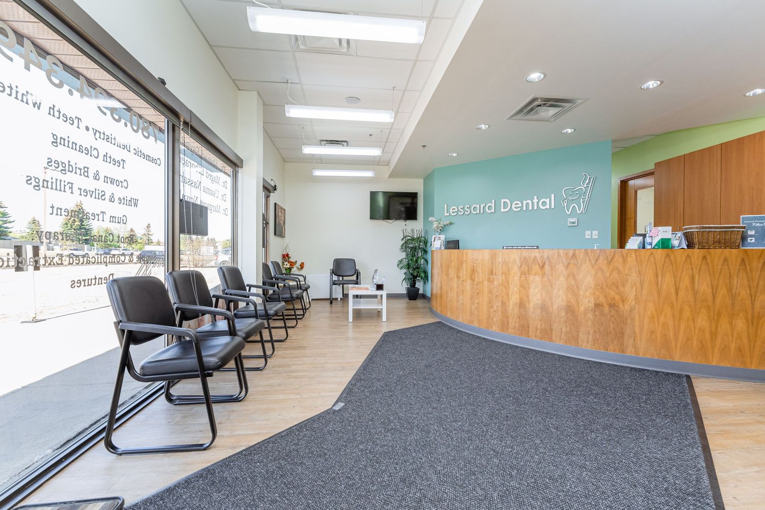 Spacious dental office waiting area with grey carpeting and wooden wall panels.