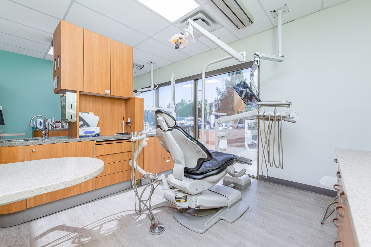 Dental operatory room equipped with modern chair and treatment equipment.