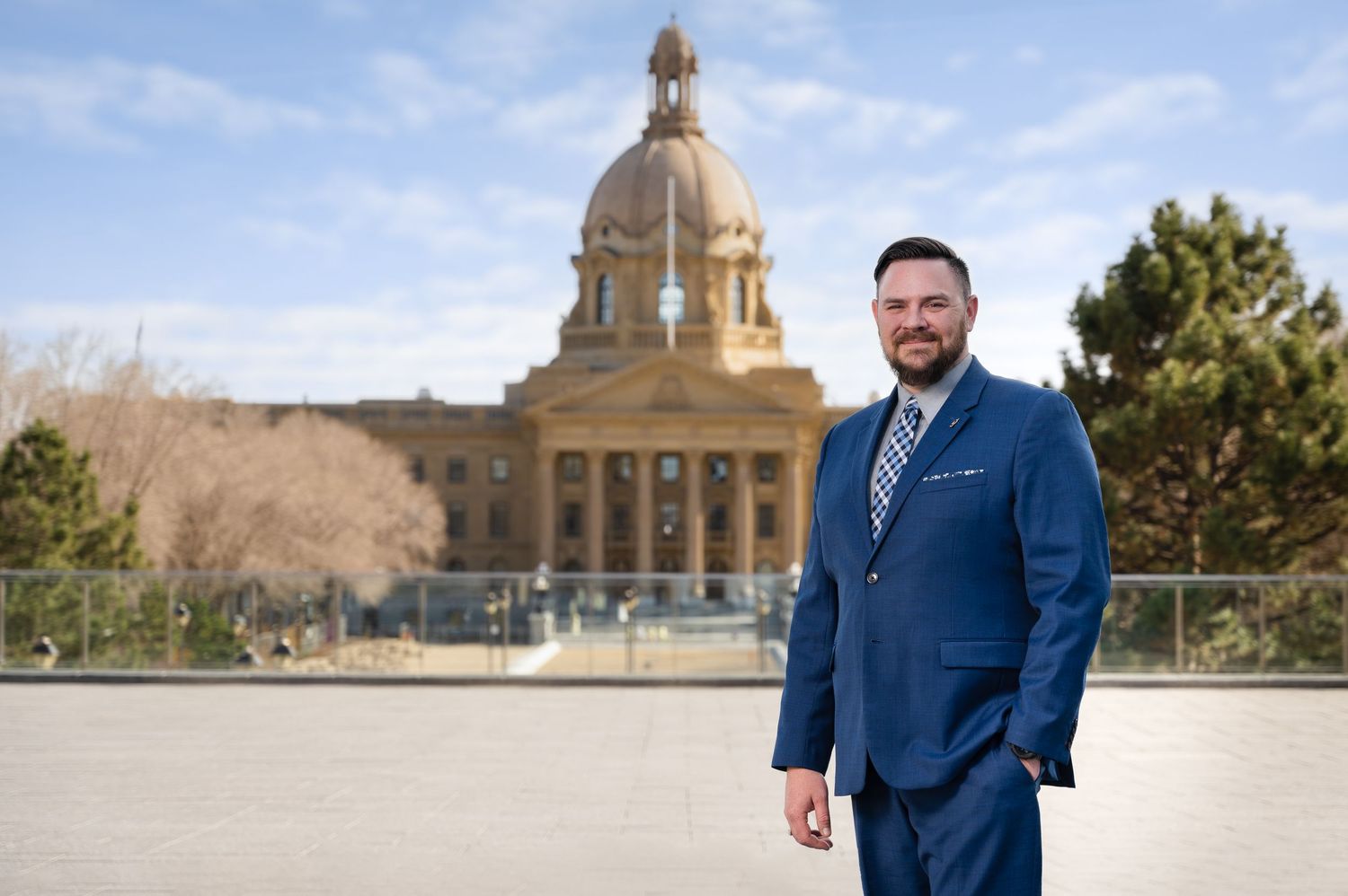 Historic domed government building with blue sky and mountains in background.