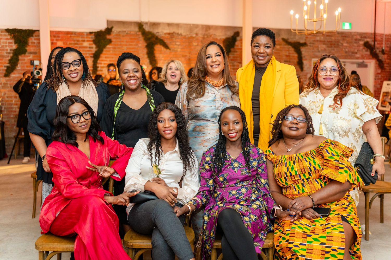 A group gathering in a warm-lit room with colorful traditional African attire and festive decor.