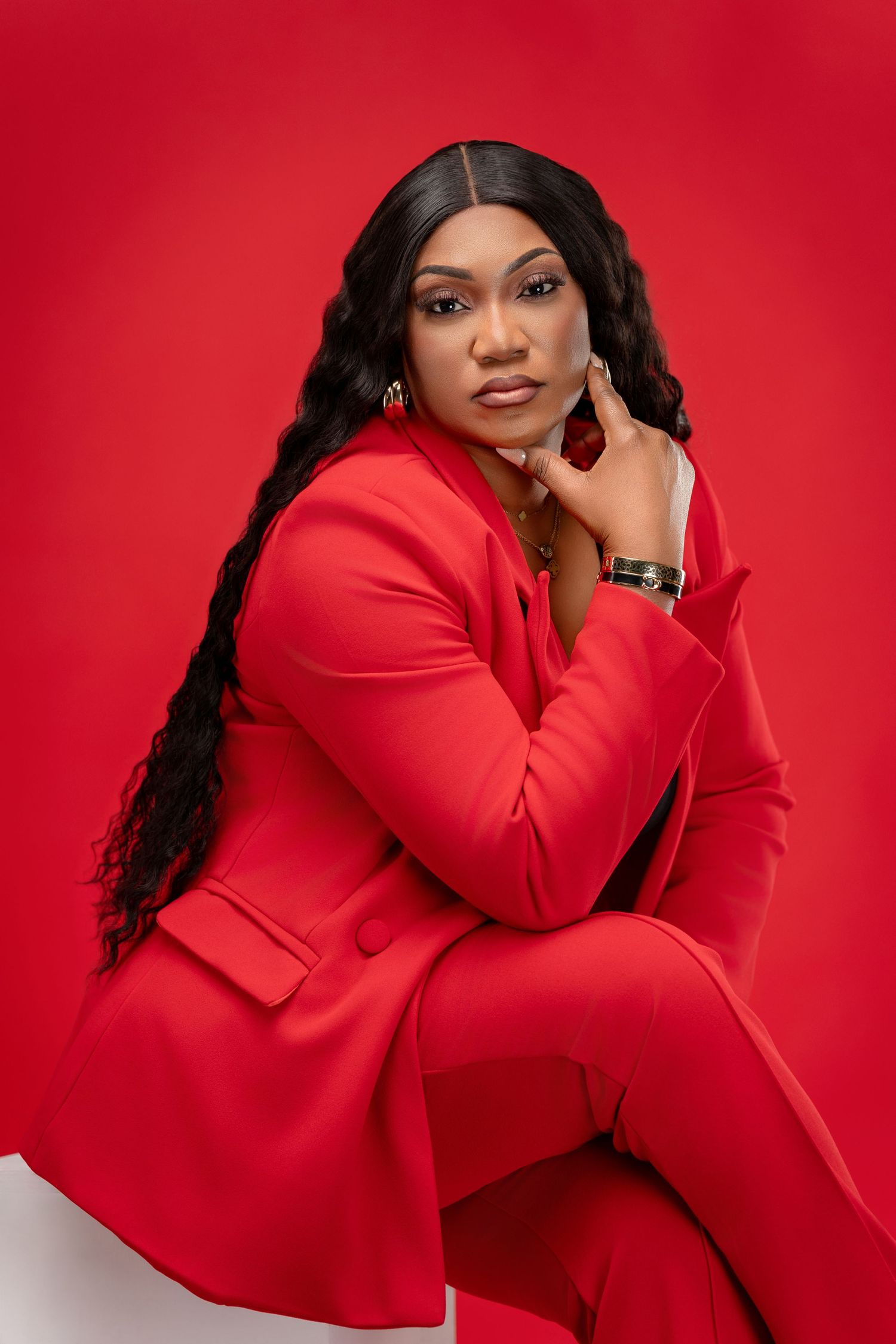 Fashion portrait series in vibrant red blazer against red background.