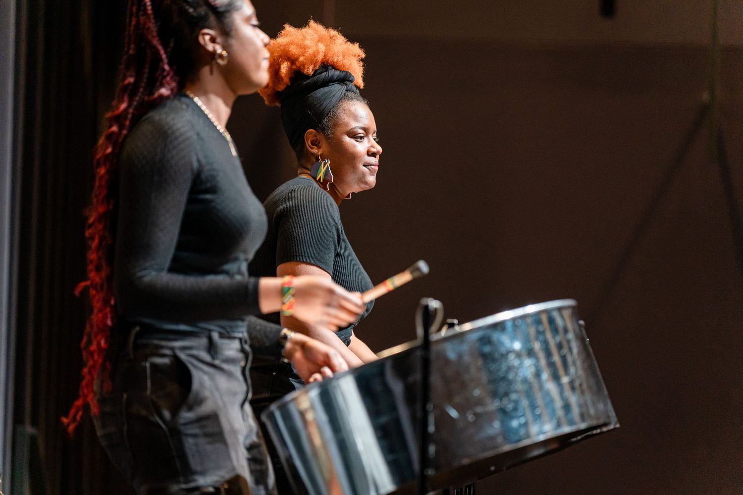 Musicians performing with traditional drums in a theatrical setting.