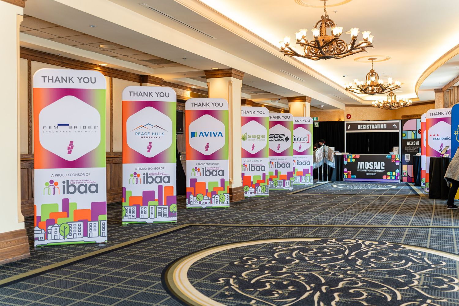 Conference hall interior with colorful banner displays and ornate chandeliers.