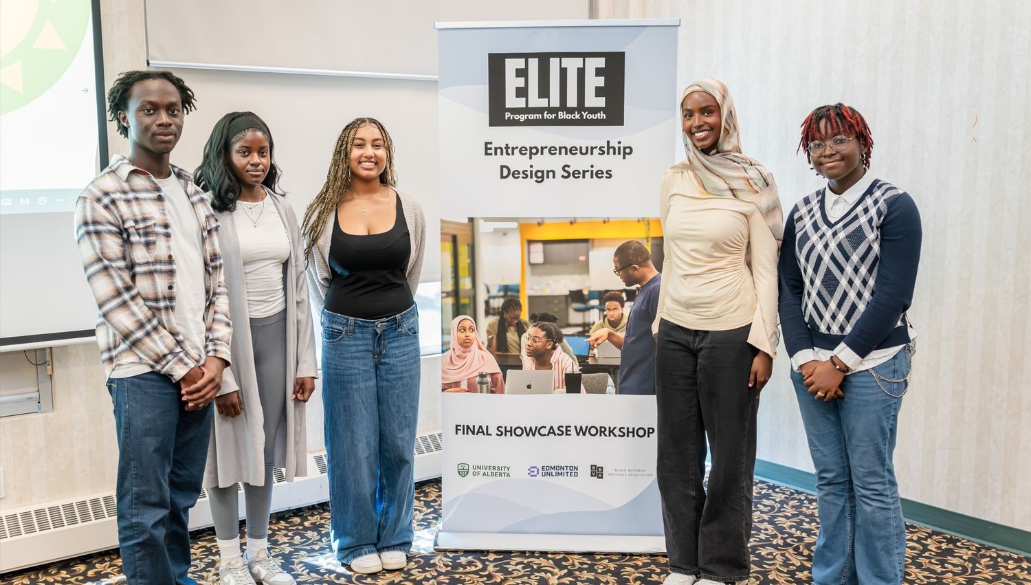 Group photo of students and faculty with ELITE banner at educational event.