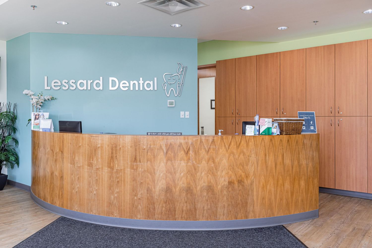 Panoramic view of dental office reception area with wooden paneling and blue accent walls.