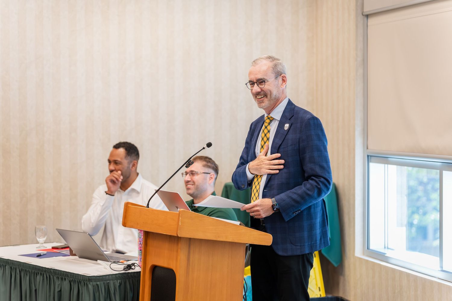 Speakers presenting at a podium during a professional conference.