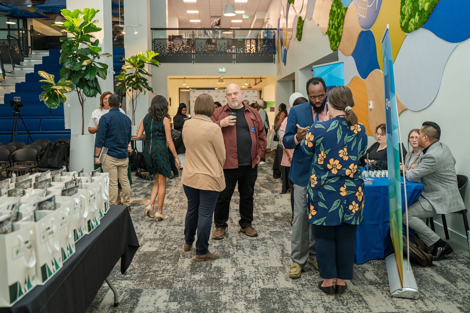 Event space with attendees gathering around promotional displays and banners.