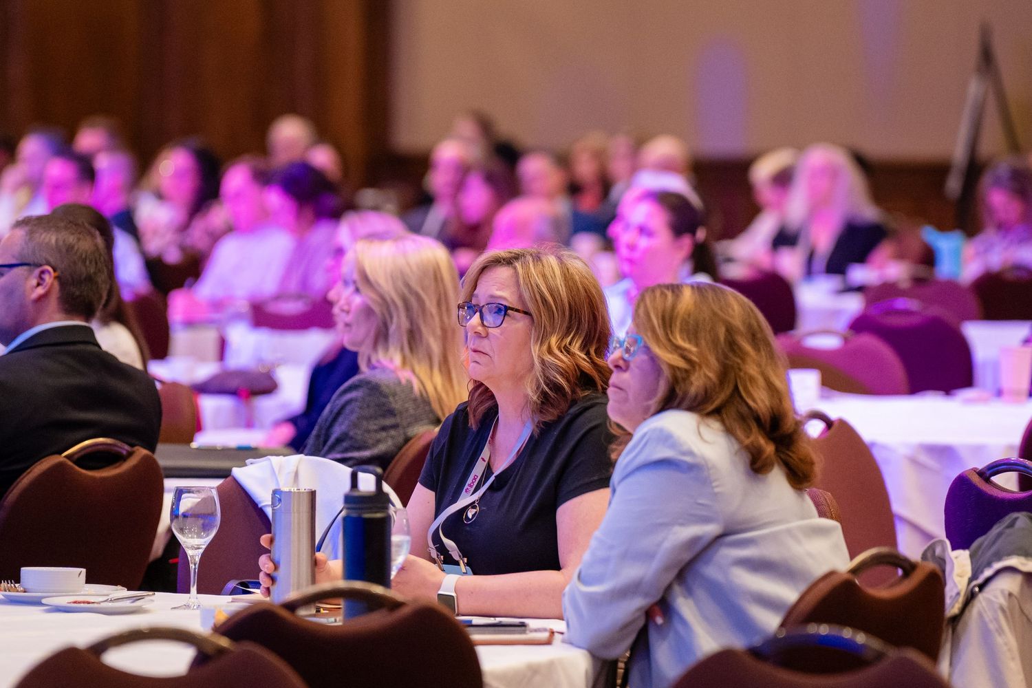 Conference attendees seated in rows at professional development event.