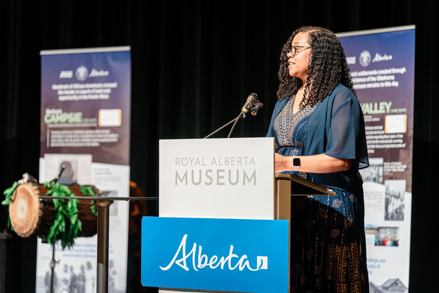 Cultural performance with Alberta signage visible in the background on stage.