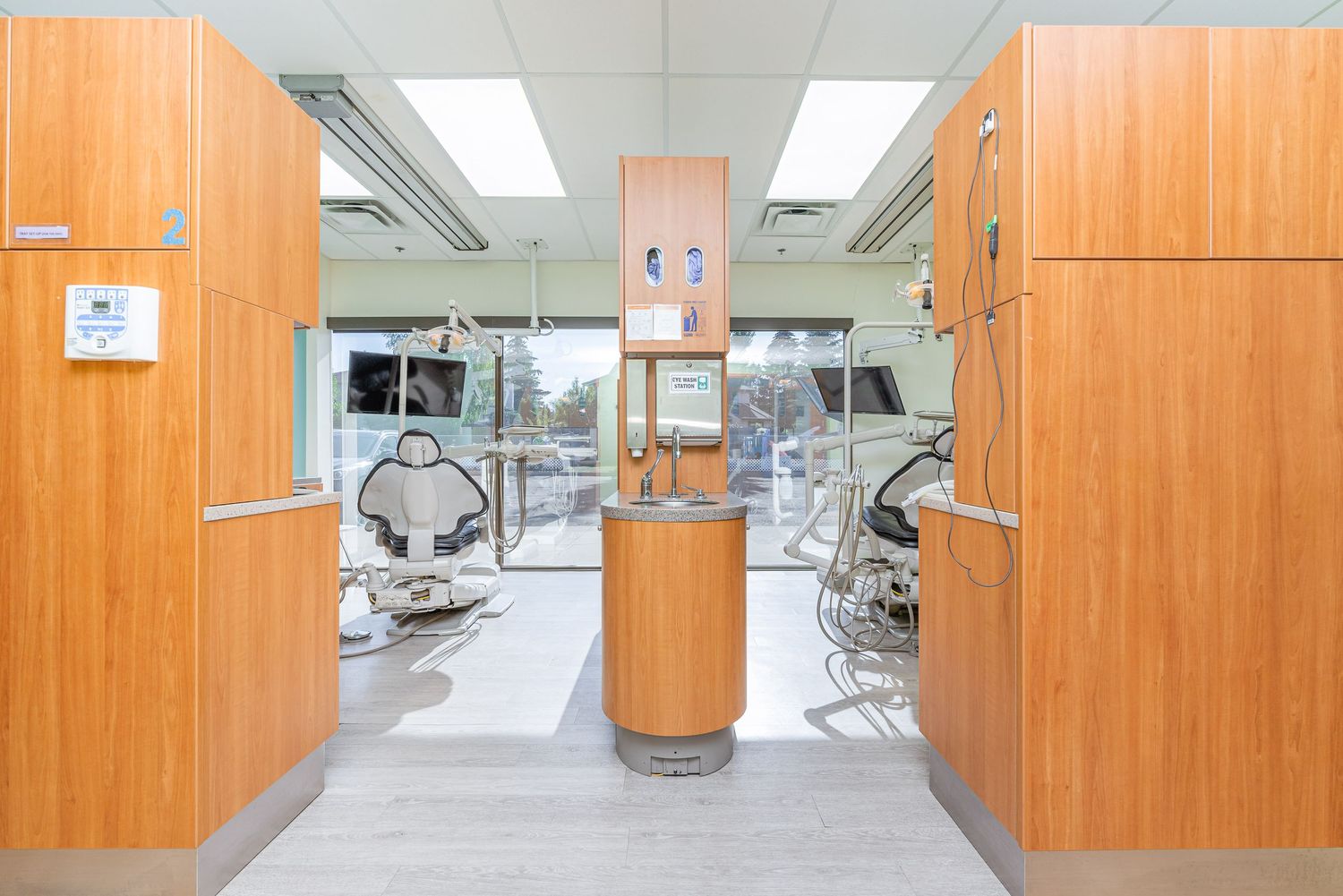 Wide view of dental clinic hallway with wooden cabinetry and treatment rooms.