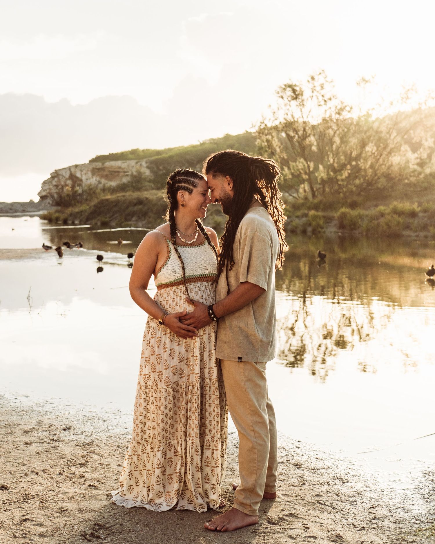 Romantic couple photoshoot at a lakeside beach during sunset.