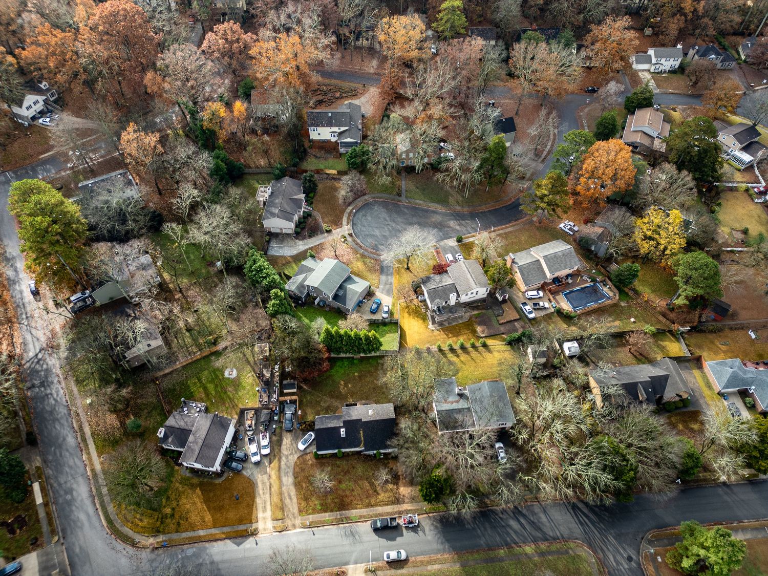 Bird's eye view of suburban development nestled among fall-colored trees.