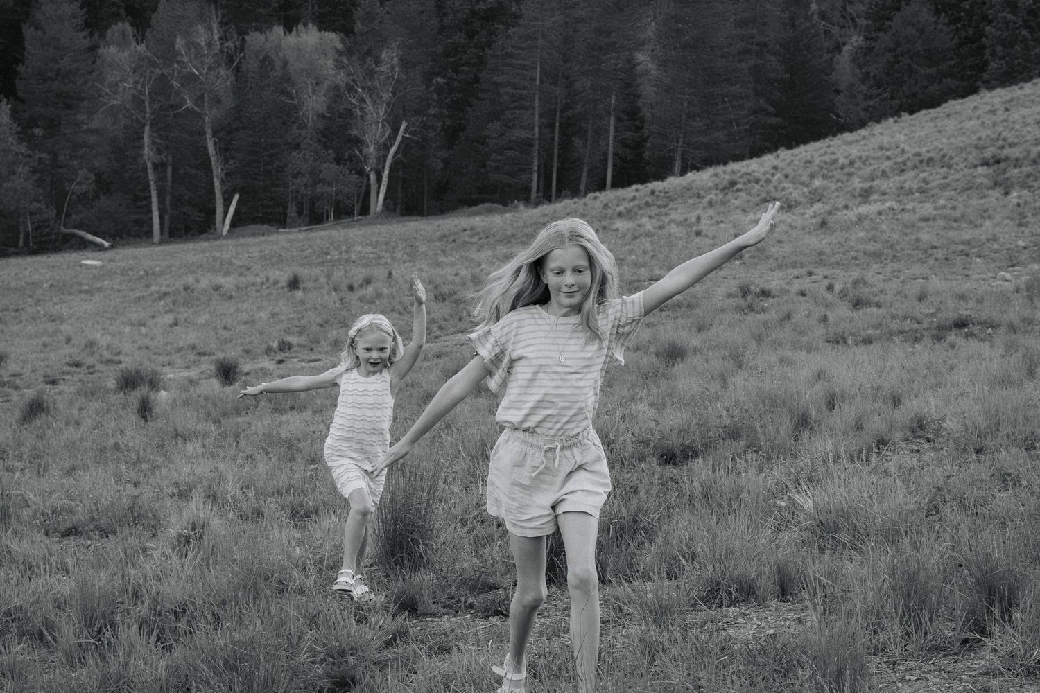 Children playing and running joyfully in a mountain meadow.