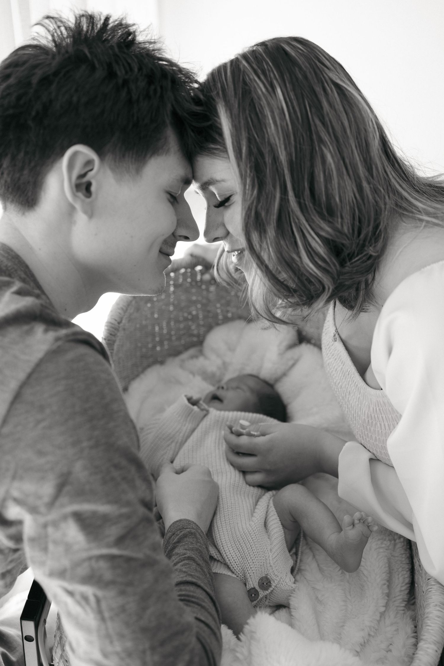 Black and white photo sequence showing tender family moments with a newborn baby.