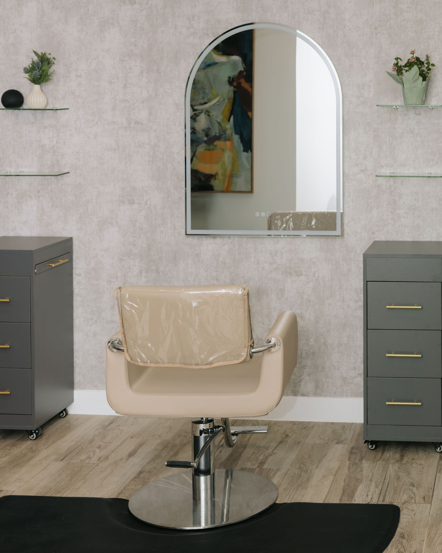 Modern salon interior with grey cabinets, mirrors and cream-colored styling chairs.