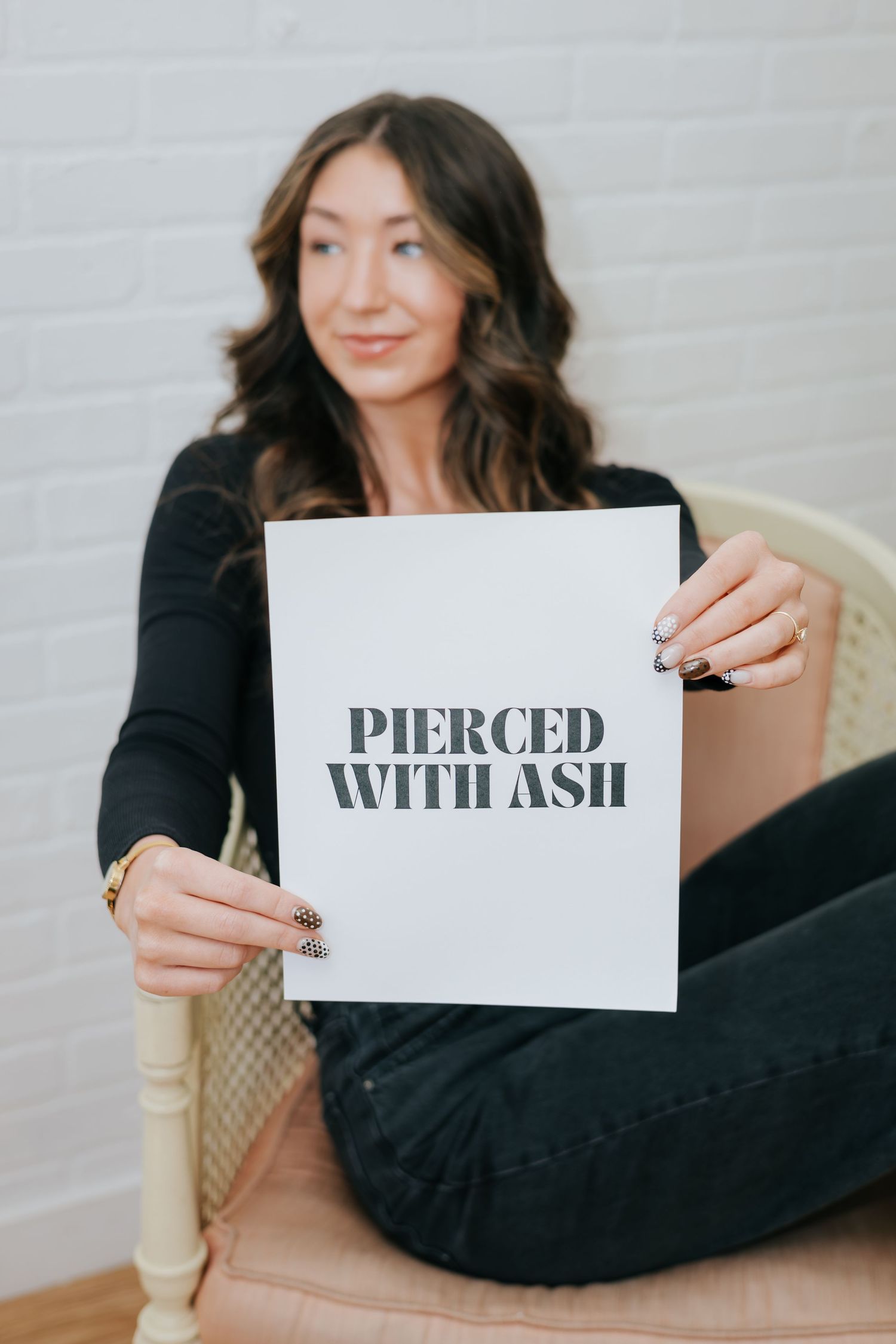 Someone holding up white cards with text while sitting in a chair.