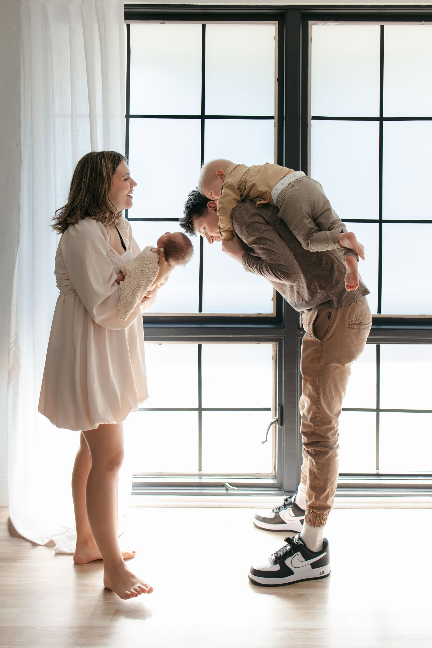 Progressive sequence of two people bending down to peek through windows.
