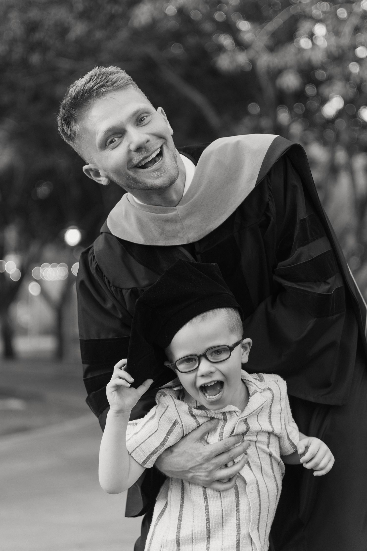 Joyful graduation portrait showing special moment between graduate and young child.