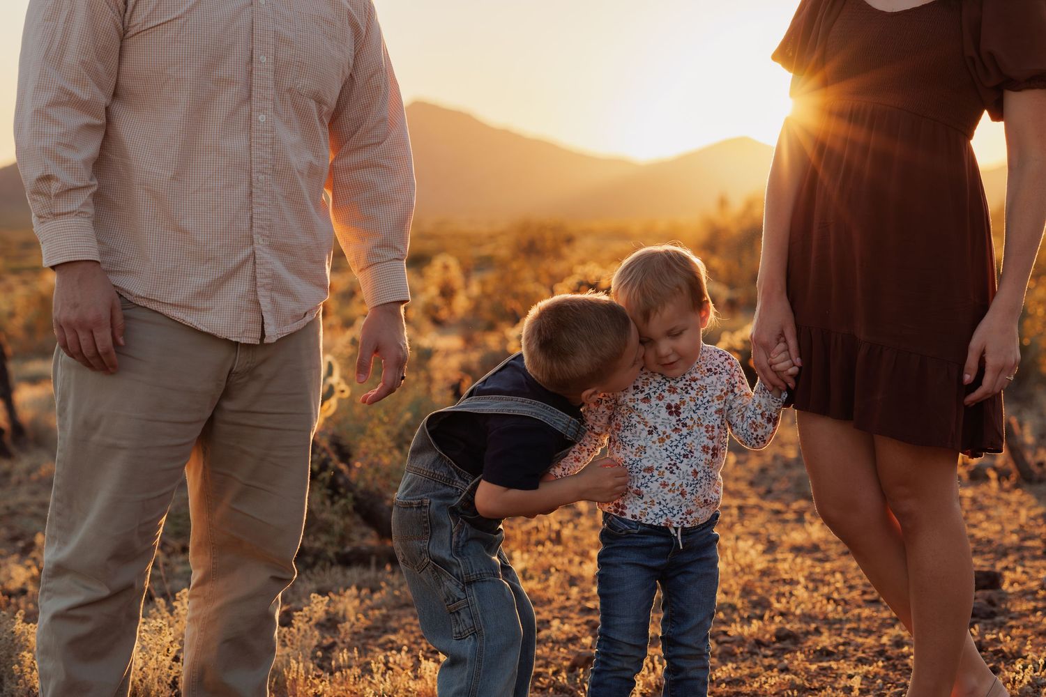 Family gathering in desert landscape during golden hour.