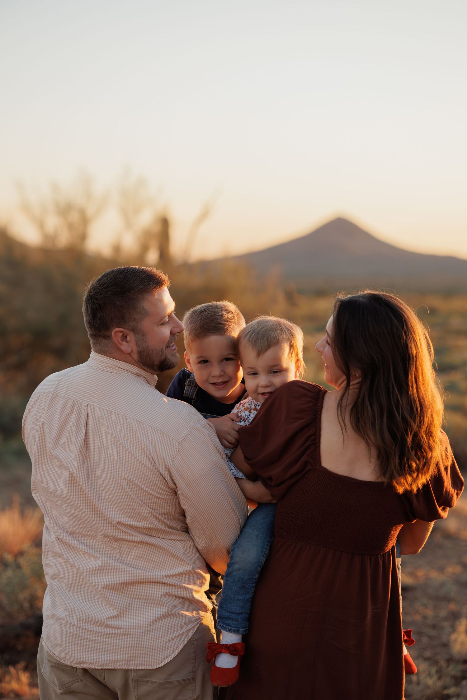 Family embracing during sunset in Arizona desert landscape.