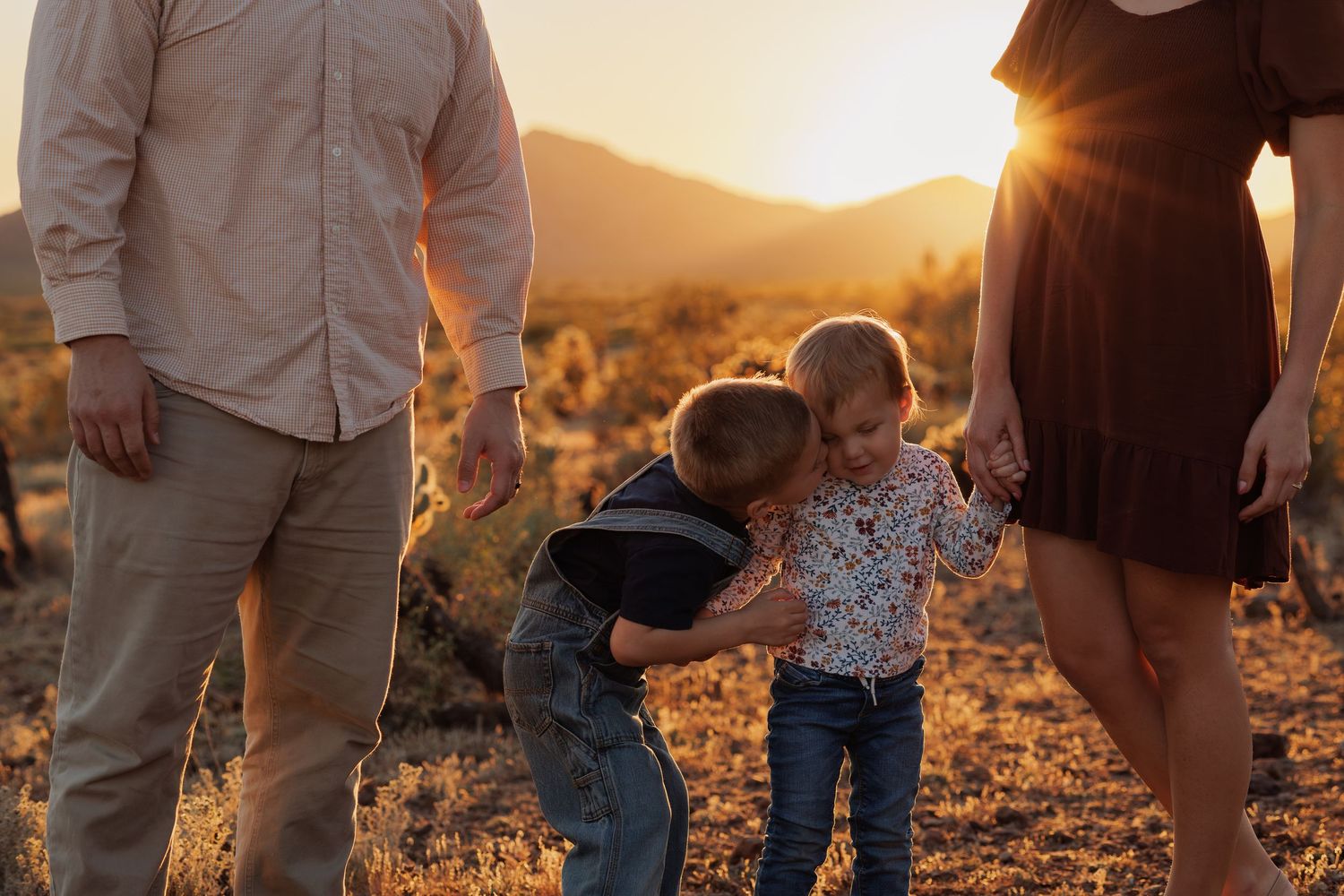 Family walking together at sunset in a mountainous landscape with golden light filtering through.