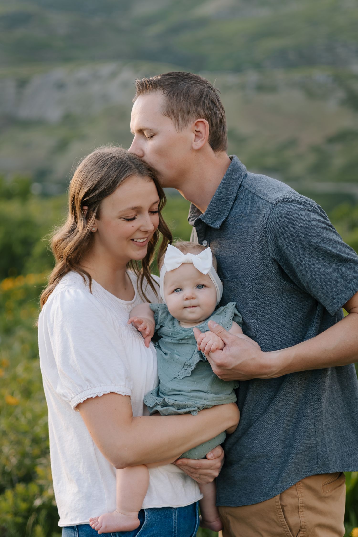 A tender family moment captured against a scenic mountain backdrop.
