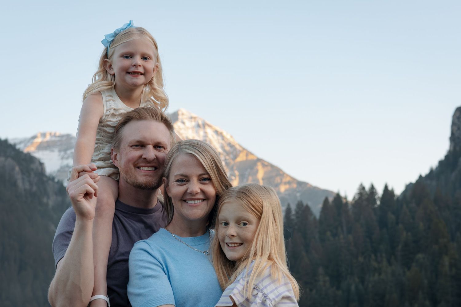 Family enjoying outdoor moments against scenic mountain backdrop at sunset.