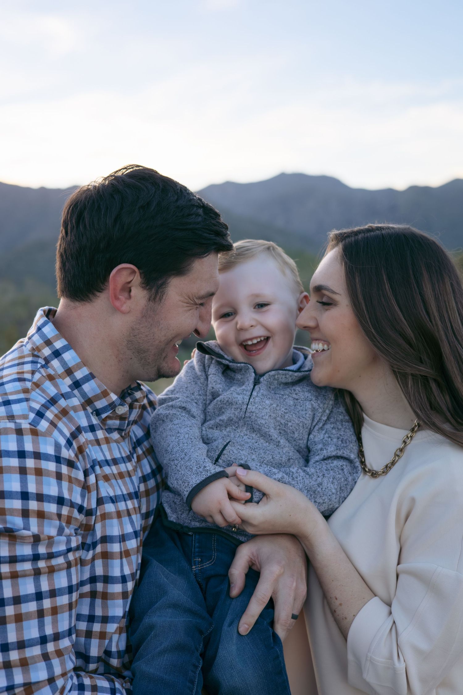 Family portrait against mountain backdrop in casual attire.